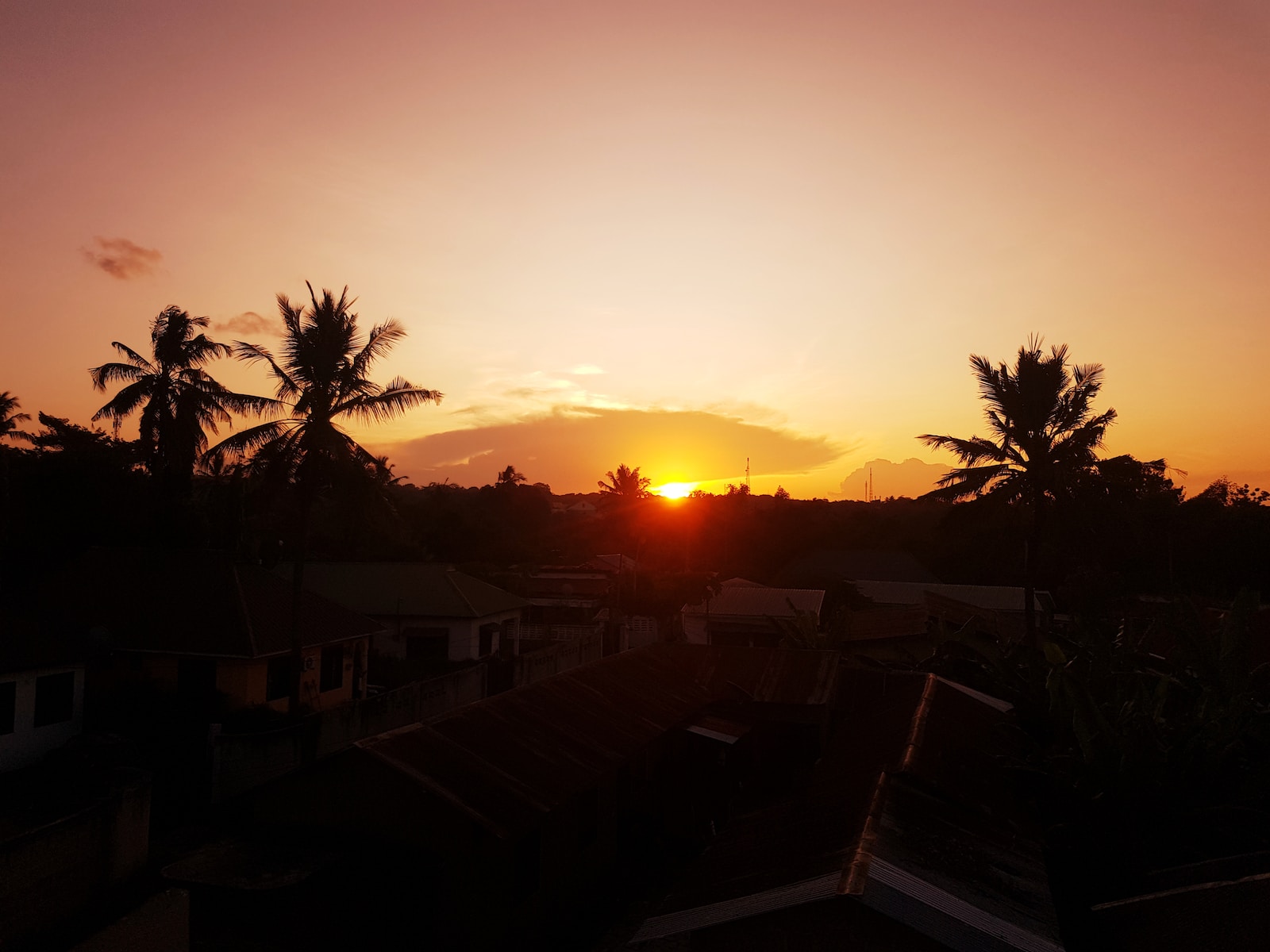 the sun is setting over a small town